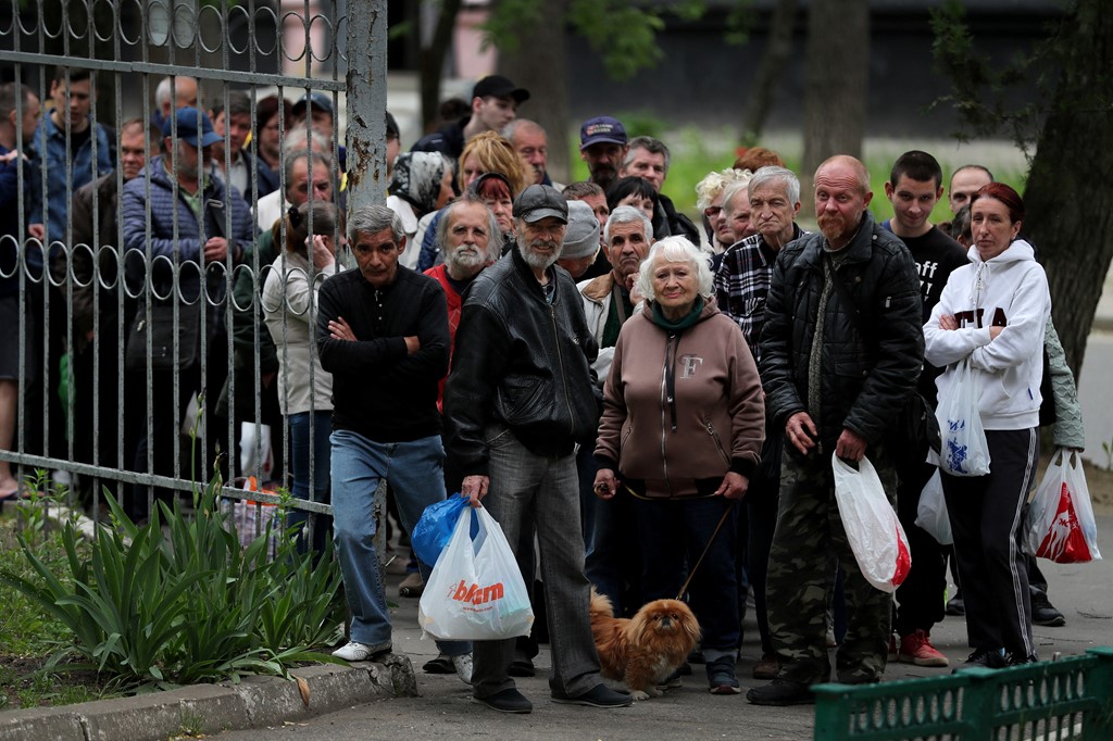 当地居民聚集在哈尔科夫的一所学校外接受人道主义援助。