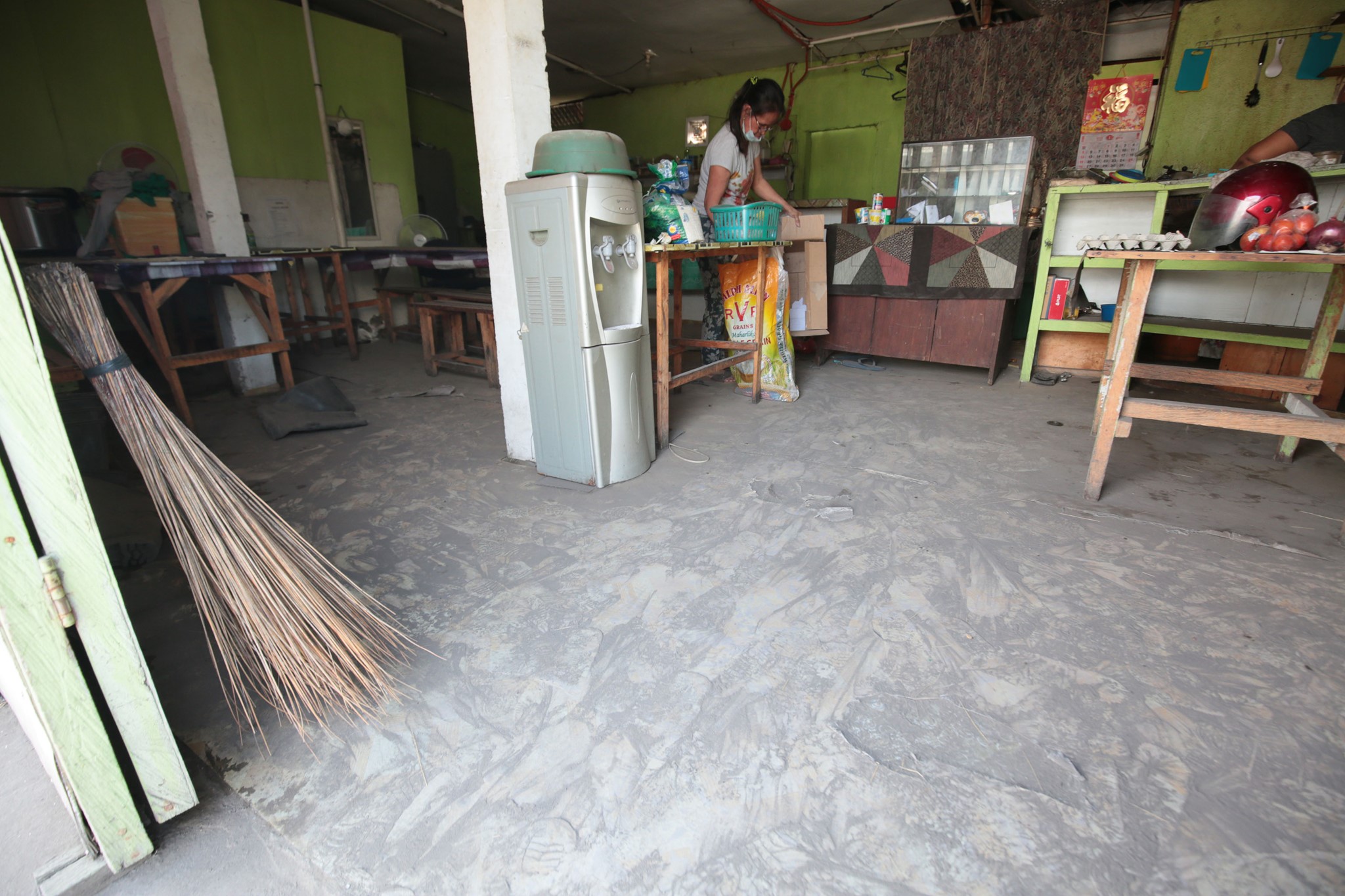 A Lemery resident cleans up her home after being allowed to return two weeks following Taal Volcano erupted last January 12.